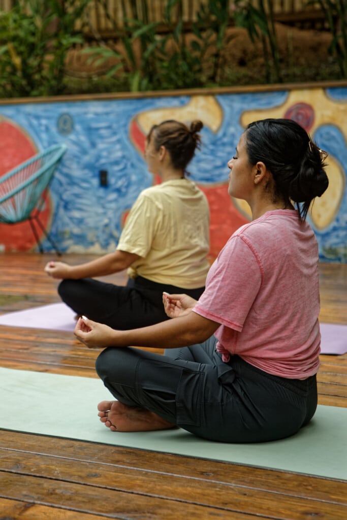 Two guests doing yoga on the mural deck