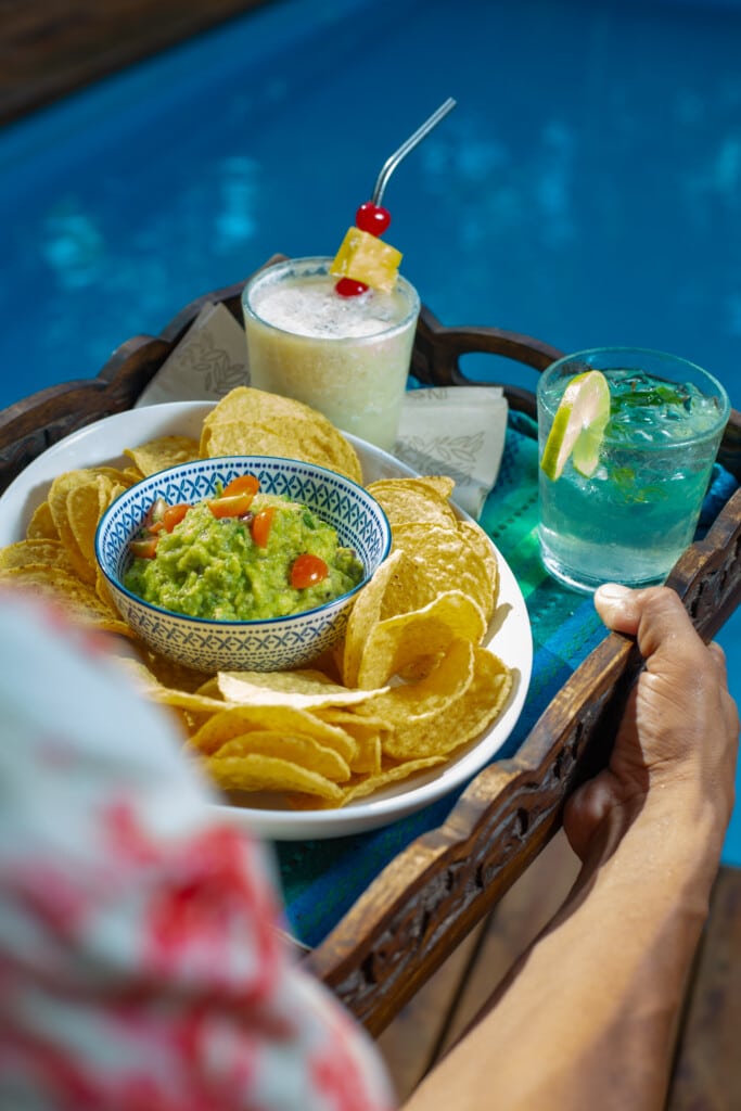 Poolside tray with chips, guacamole and a frozen drink