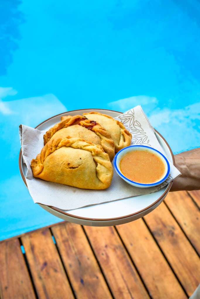 Empanadas with dipping sauce served poolside